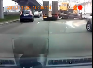 В Киеве бульдозер на ходу слетел с перевозившего его тягача